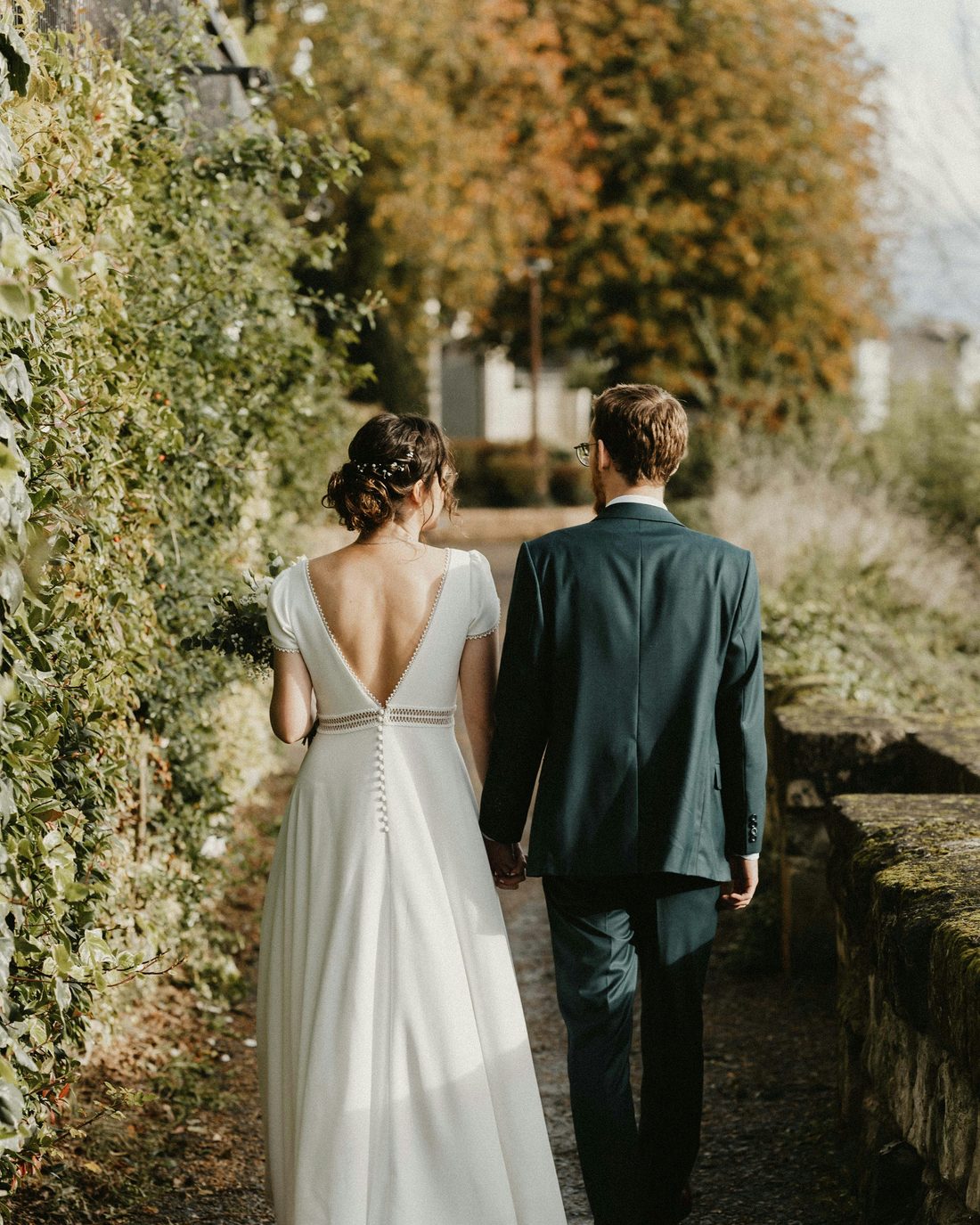 A couple walking away together down an autumn path