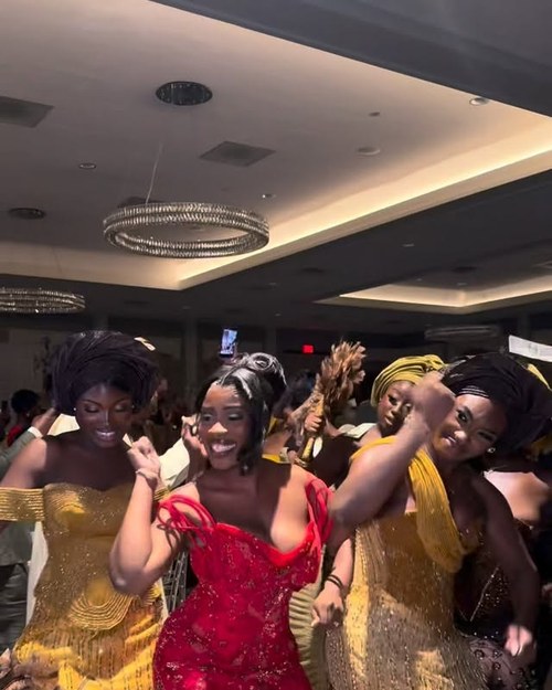Guests dancing in kente and gold at the reception